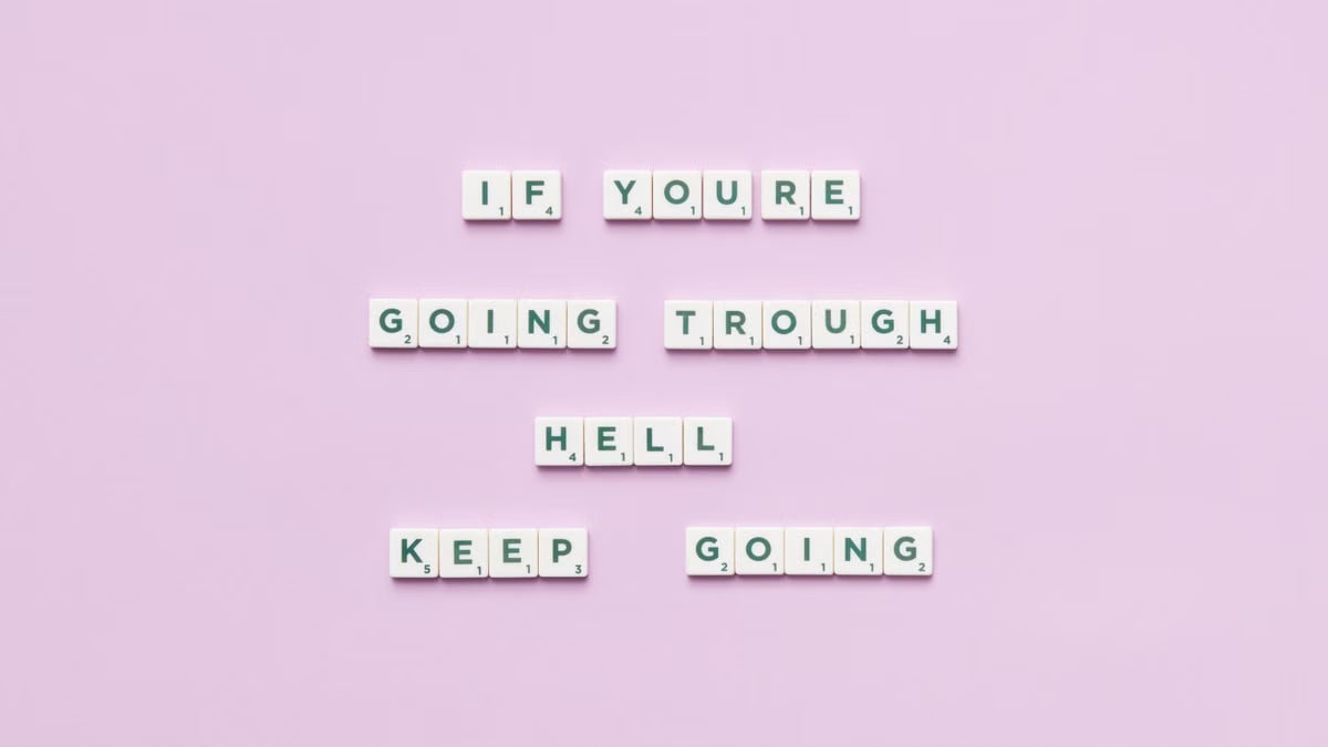 Motivational text using letter tiles on a purple background.